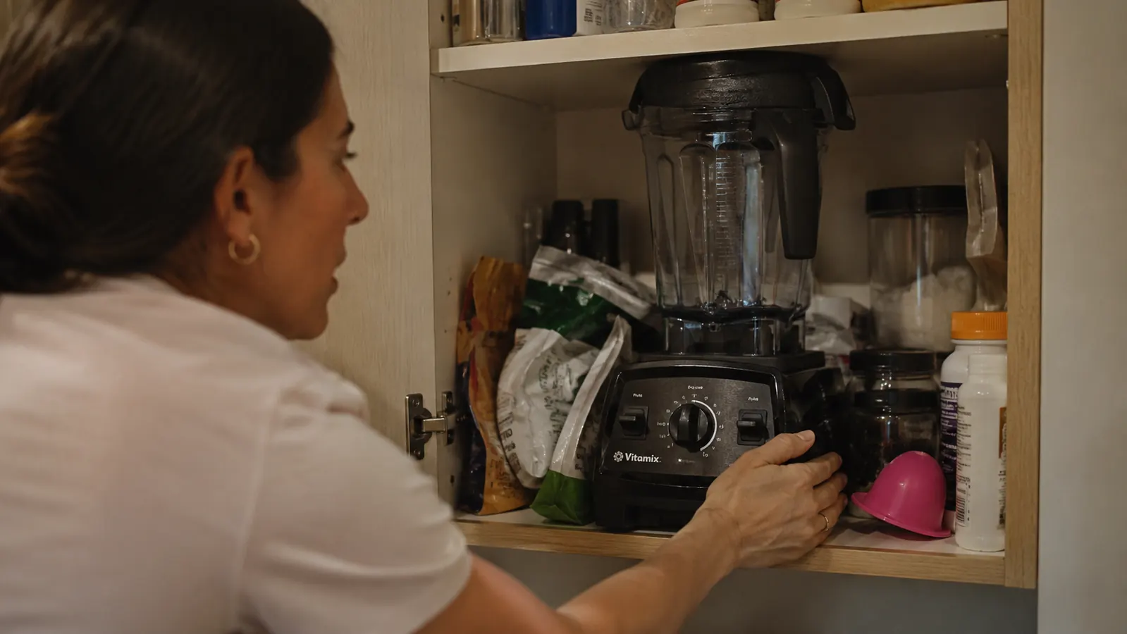 Open kitchen cabinet with a large full-size blender taking up most of the shelf space